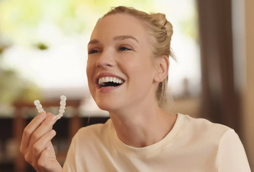 smiling young woman holding Spark clear aligners.jpg
